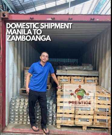 Man standing beside shipment crates inside a container.