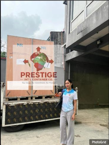 Woman standing beside a large crate on a truck.