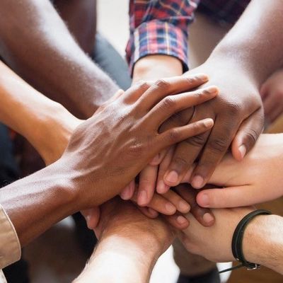 Diverse hands stacked together in unity.
