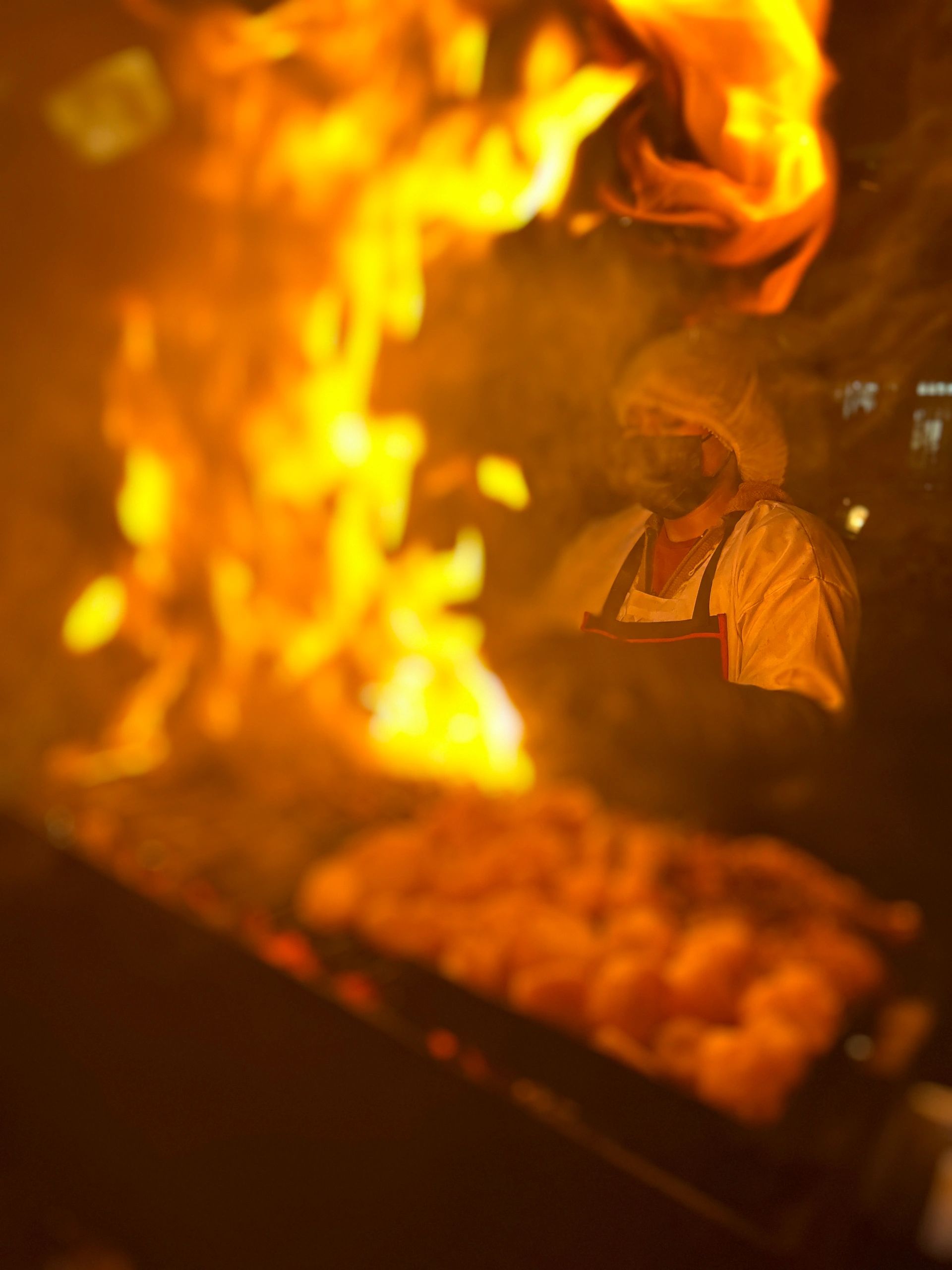 Persona cocinando con fuego intenso.