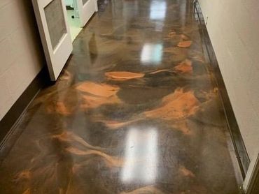 Shiny polished floor with a marbled brown and black design in a hallway.