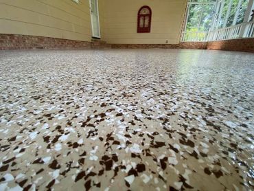 Close-up of a speckled epoxy garage floor with a glossy finish.