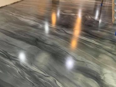 Glossy, marbled floor with swirling gray and black patterns reflecting overhead lights.