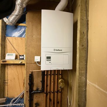 Wall-mounted Vaillant ecoFIT pure boiler with copper and black pipes.