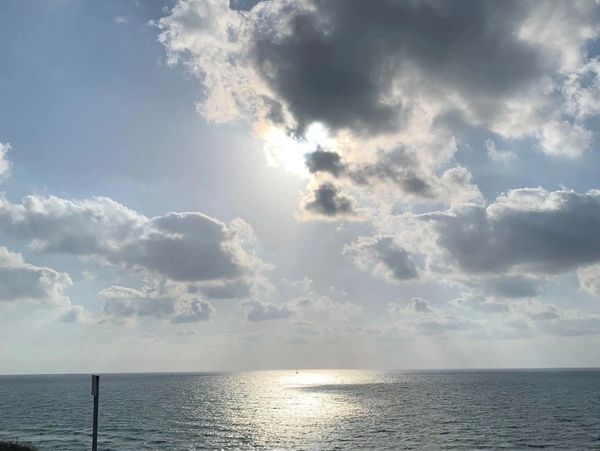 pier with sun peeking through the clouds
