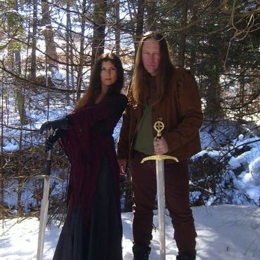 Heather and Frank from Medieval/Fantasy Folk Rock band Elflore in the snow holding swords