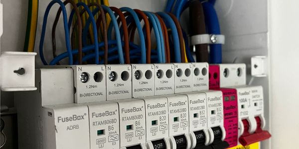 Close-up of an electrical fuse box with labeled switches and organized wires.