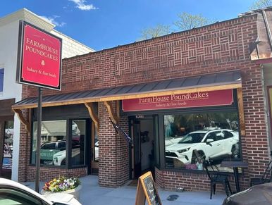 Exterior of Farmhouse Poundcakes bakery with outdoor seating and clear signage.