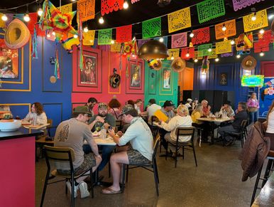 Colorful Mexican restaurant with festive decorations and diners enjoying meals.