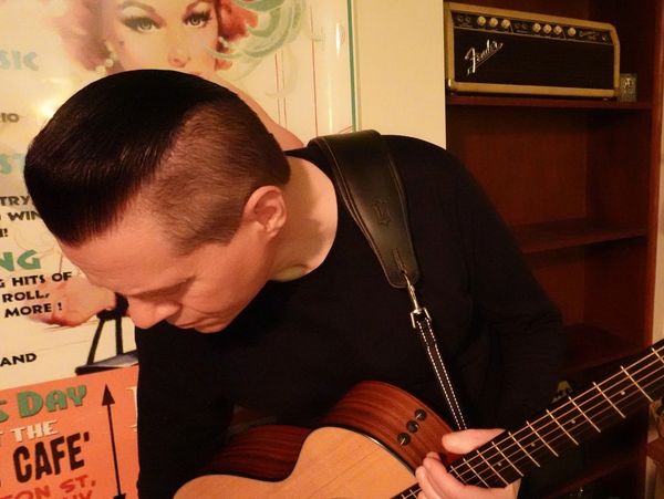 singer holding acoustic guitar