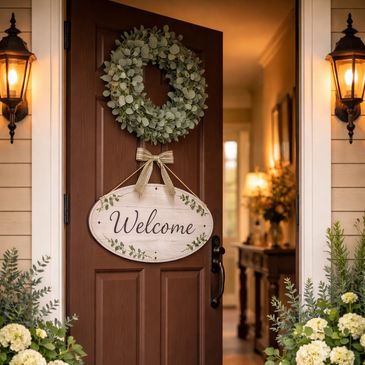 Warm welcome sign and greenery on a cozy front door.