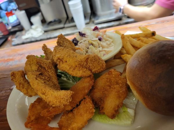 Plate with fried fish, coleslaw, fries, and a bun.