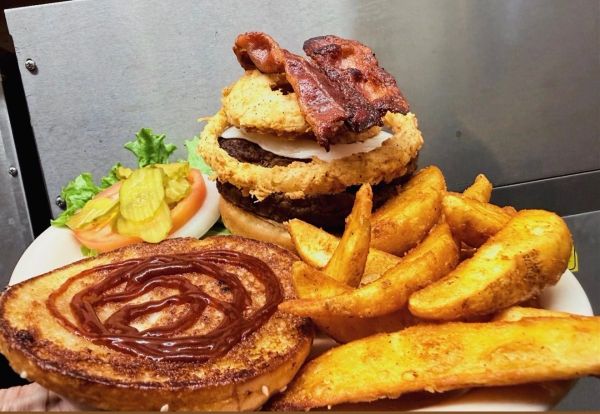 Loaded burger with bacon and potato wedges.