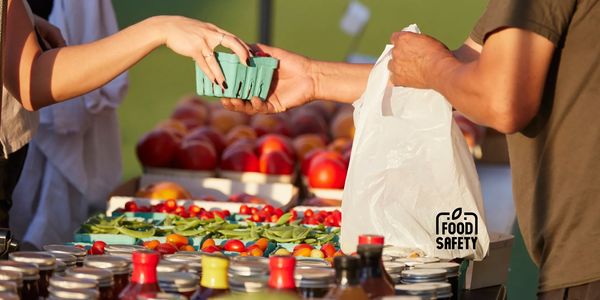 A person buying fresh produce at a market with a focus on food safety.