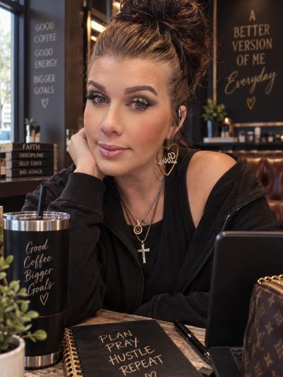 Woman sitting at a table with motivational signs around her.