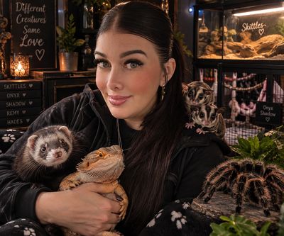 Woman holding exotic pets including a ferret and bearded dragon.