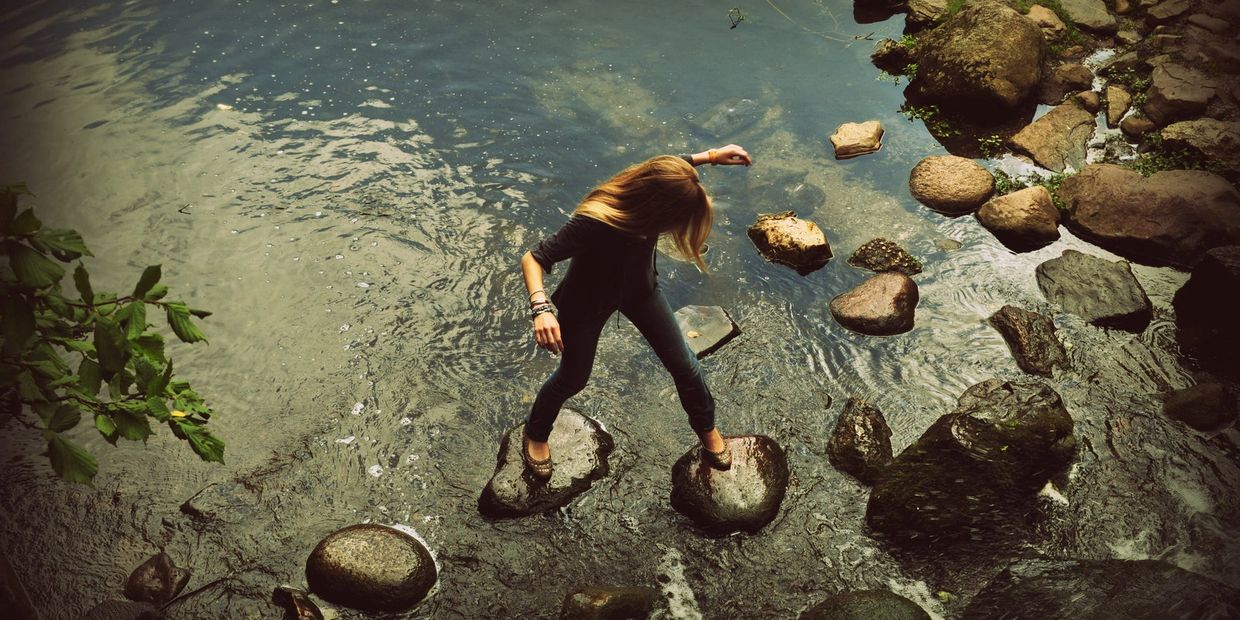 Girl walking over stepping stones in water- Photo Courtesy of Daniel I Obubo, with thanks.
