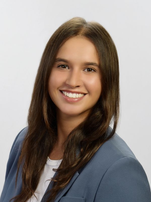 Young woman with long brown hair smiling.