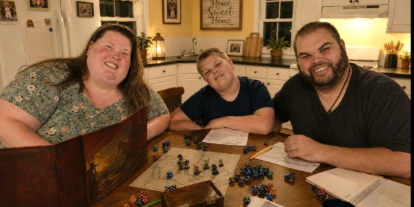 Family playing a tabletop role-playing game at home.