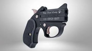 A compact black Derringer pistol with engraved text on its barrel.