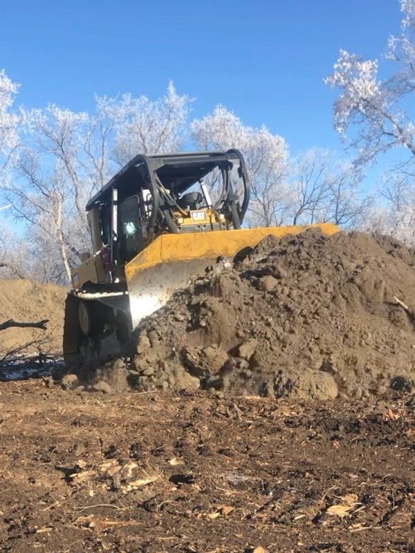 Bulldozer pushing a pile of dirt.