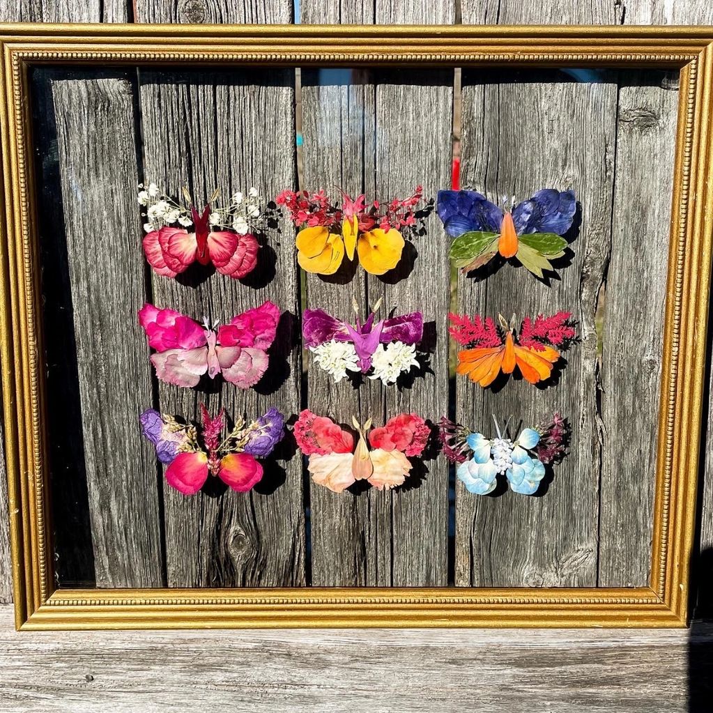 Nine, multi-colored, pressed flower butterflies, between glass in gold, vintage frame.