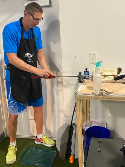 A Man Fixing a Table Wearing an Apron