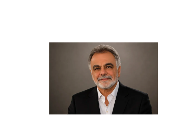 Smiling mature man with gray hair and beard in formal attire.