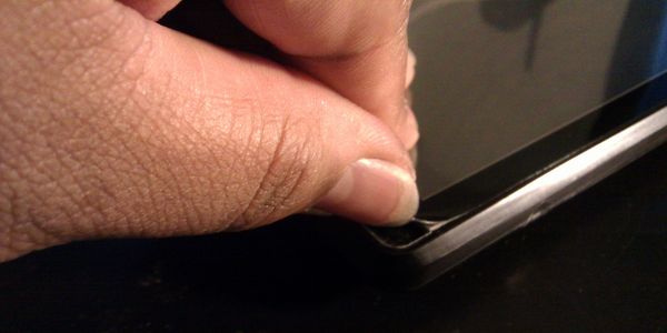 Hand peeling back a screen protector