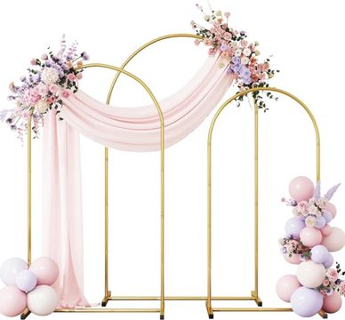 Elegant gold wedding arch with pink drapes and floral decorations.