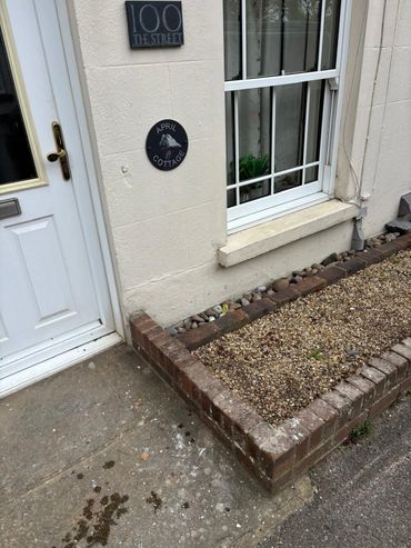 Exterior of a cottage with a white door and window, marked 'April Cottage' at 100 The Street.
