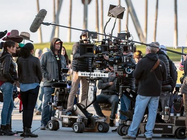 Professional film crew setting up equipment on set, showcasing Film Production Services with cameras, lights, and crew working together.