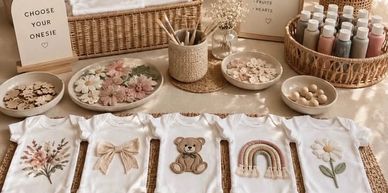 Customized baby onesies with cute designs and crafting supplies.