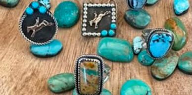 Assorted turquoise rings with silver and unique stone patterns on a wooden surface.