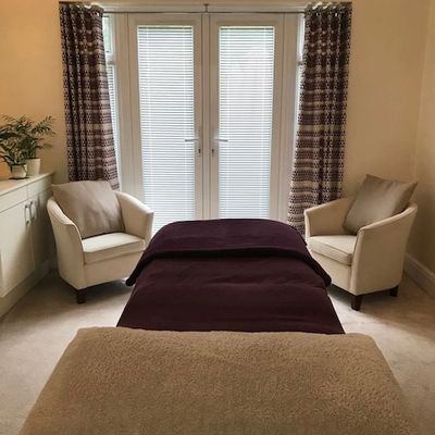 Image of a treatment room with couch and two chairs for consultation