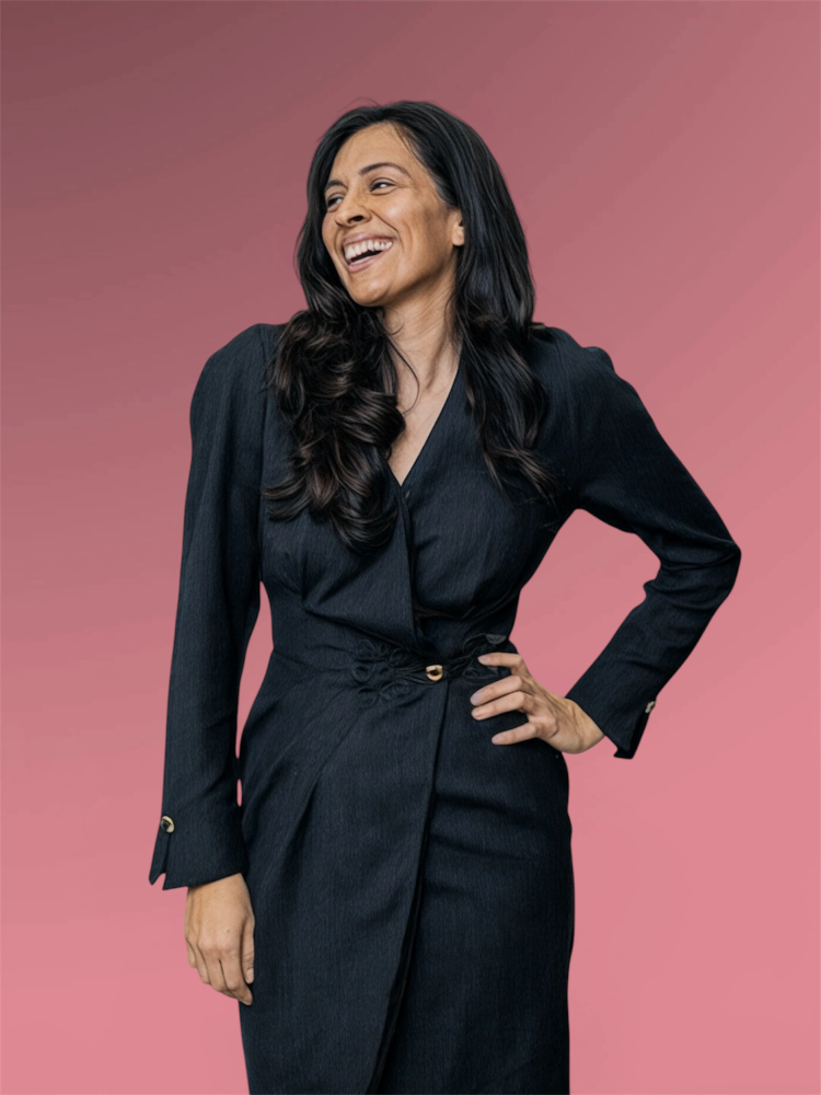 Woman laughing joyfully in a black dress.