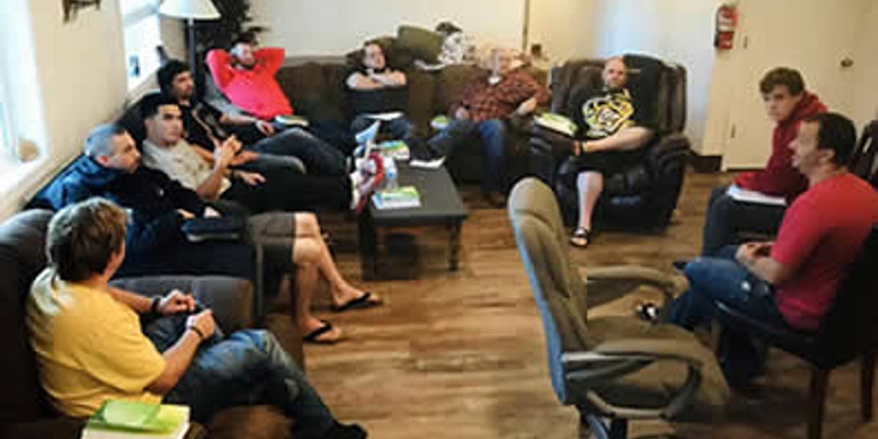 Group of men in a casual meeting relaxing on couches and chairs.