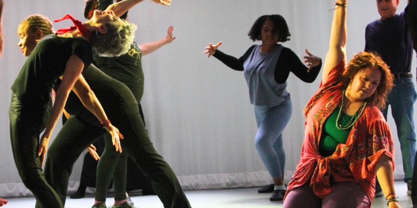 People dance expressively in a group with dynamic poses.