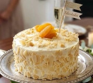 Bizcocho de almendra, jarabe de almendra, betún de queso con trocitos de chabacano y almendra tostad