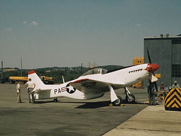 1970's picture of small aircraft at airport. First picture on page with color.