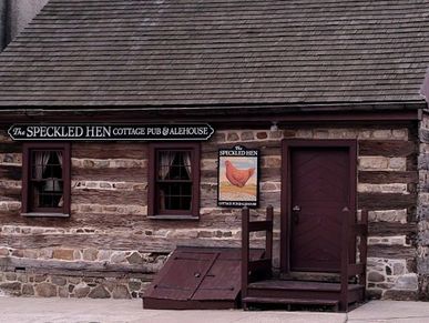 Log cabin with picture of hen in front.