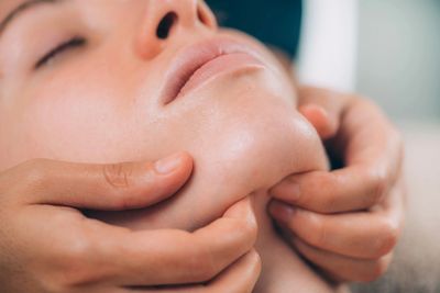 Close-up of a person receiving a facial massage.