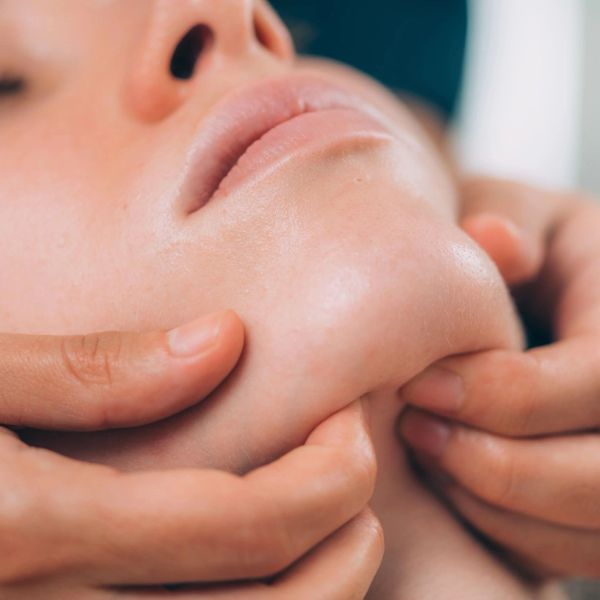Facial massage focusing on the chin and jaw area.