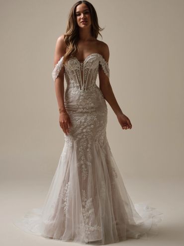 A dramatic fit and flare wedding dress with  a plunging sweetheart neckline and beaded lace details 