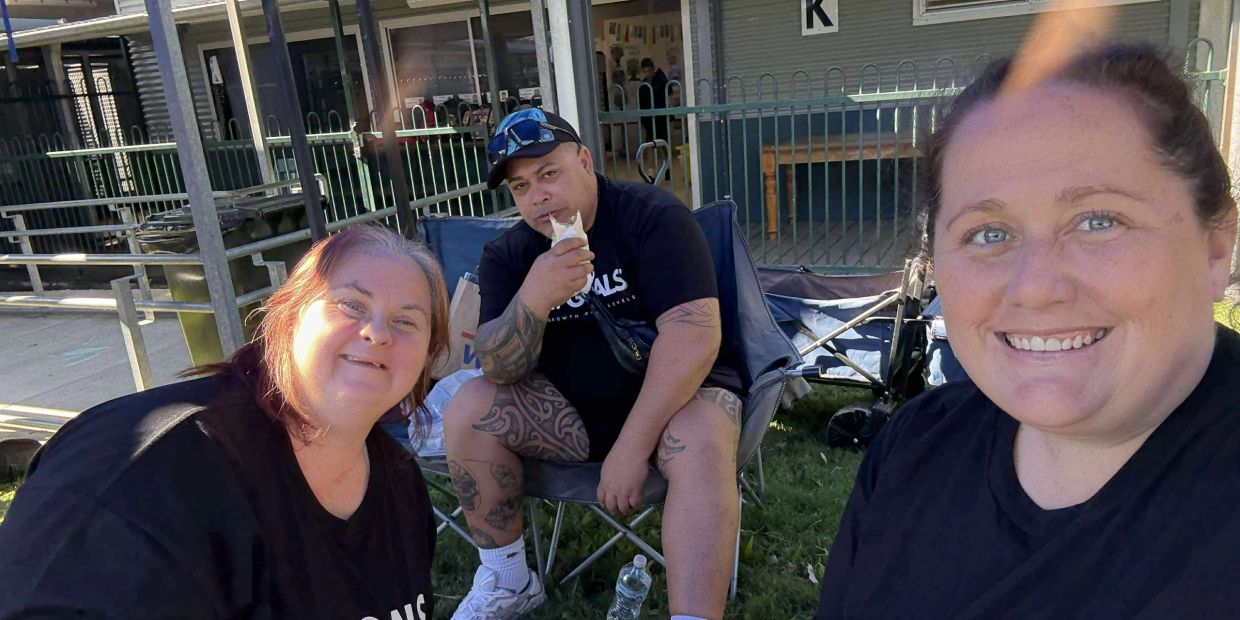 Three people enjoying a sunny day outdoors, smiling and relaxing.