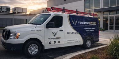 Veterans HVAC/R service van parked outside a commercial building at sunset.