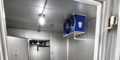 Interior of a clean, industrial refrigeration room with cooling units.