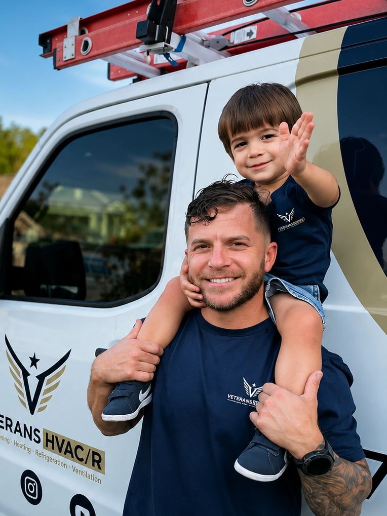 A man carries a smiling child on his shoulders by a Veterans HVAC/R van.