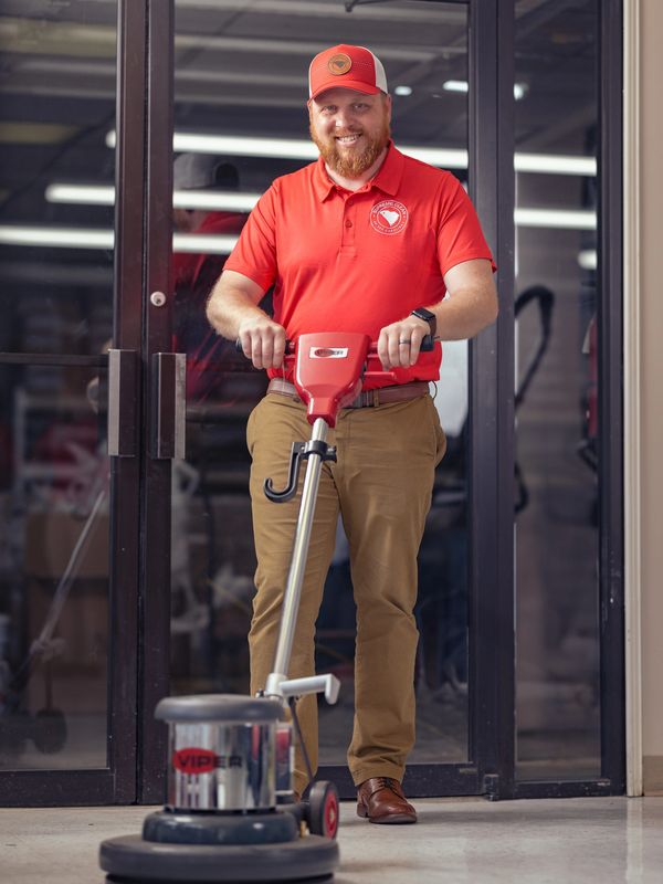 A professional man using a floor cleaning machine.