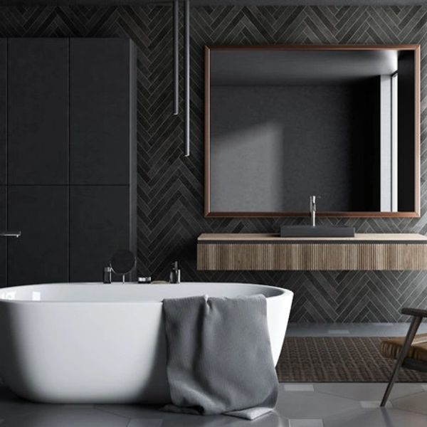 Modern bathroom with freestanding tub and dark walls.